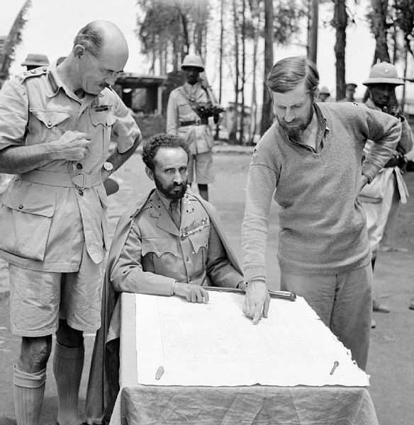 Haile Selassie glances up from table as Orde Wingate points out a feature on the map, 1941 [Public domain, Imperial War Museum/wiki]