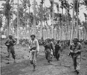 The US 112th Cavalry Regiment moves through a coconut plantation in Arawe [Public domain]