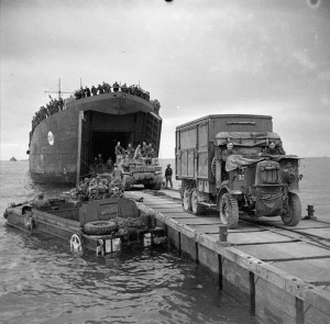 British troops bring equipment ashore at Anzio; an American DUKW is floating alongside the jetty; January 1944 [Public domain]