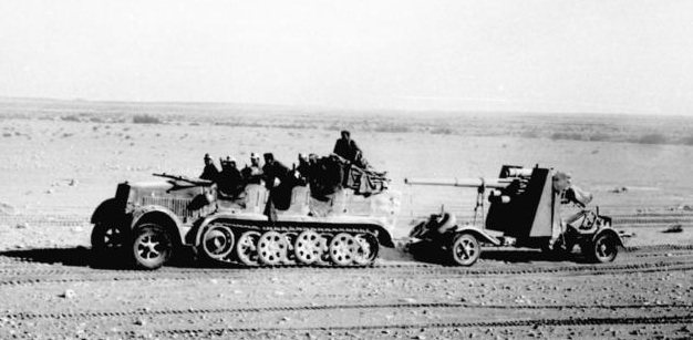 Soldiers of Rommel's Afrika Korps haul one of their 88mm flak/anti-tank guns across the desert, North Africa, 1941 [Bundesarchiv Bild 101l-783-0109-19/ Dorner/ CC-BY-SA, wiki]